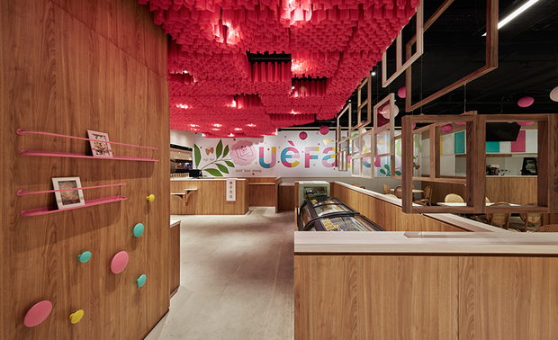 
接待区、柜台区
Reception area、cashier counter

接待区与用餐区间悬挂木皮窗框，隔而不断地划分花树与家宅的意境，框内间或装设透明压克力板，供商家陈贴当季广告文宣；侧边入口柱体立面的彩色壁饰，可作为挂钩挂上购物袋，让客人取用并入内选购商品。

We hang wooden window frames to slightly separate the reception and dining areas and present a homey look. Moreover, we inlay transparent acrylic sheets into some windows that are handy for posting seasonal advertising. On the teak veneer column of the entrance, we insert a few colorful hooks for hanging shopping bags so that the customers can use them to buy food products.
