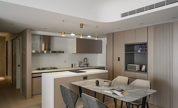 
餐厨区
Kitchen & Dining Room Combo

餐厅选用灰白石纹餐桌搭配双色餐椅，呼应公区俐落时髦氛围，比邻中岛上方悬挂金色造型吊灯，藉跳色提升此处活泼灵动感之馀，也加强烹调区照明，给予居者明亮的料理环境。

A gray marble dining table with dual-colored chairs responds to the trendy vibe of the public space. The gold pendant light above the attached kitchen island brings a vivid touch via contrast colors and brilliantly renders sufficient illumination to the countertop.
