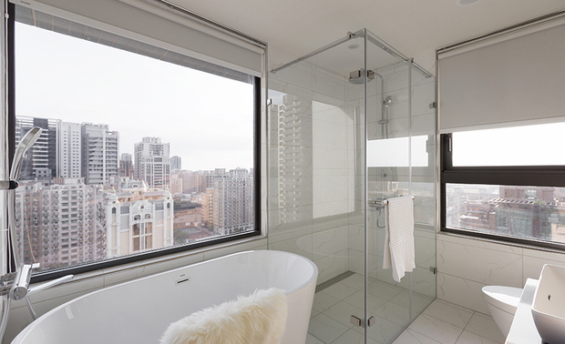 
主卧、主卫浴
Master Bedroom & En Suite Bathroom

主卧以灰白色为基调，佐搭床头木纹半牆、雾金玻璃壁灯，共同酝酿沉静温暖的舒眠氛围；卫浴充分活用採光良好的特性，规划大面窗户并摆置蛋型浴缸，当夜幕低垂之际，皎洁明月流淌入室，映耀一波波粼粼水光，入浴时，静心眺望户外美景，供住者尽享惬意的休憩时光。

The dominant neutral color matches wood-toned wainscoting and a misty glass sconce light, delivering a balmy and soothing sleep zone. Incorporated with adequate natural light, we installed large windows and an egg-shaped bathtub, allowing a pleasant view. When night falls, the gleaming water reflection by the clear moonlight favors the residents' enjoyable relaxation.
