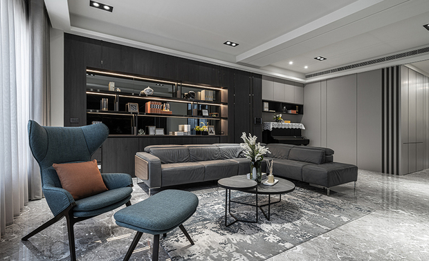 
客厅
Living Room

客厅採用玄色大理石电视牆，搭配黑白双色格栅，遮蔽后方落地窗光线，营造良好的观影品质，中央深灰基调的沙发、石纹茶几，与一旁湖水绿单人椅和砖橘色抱枕，为场域共织丰富色彩，迎来灵动的跳色景緻。

The living room features a black marble TV wall, with a monochrome lattice for optimal viewing by blocking out light from the floor-to-ceiling windows. The central sofa adopts deep gray with a stone-patterned coffee table, lake-green armchair, and brick-orange cushions on one side for a rich palette of colors, bringing life and energy with its contrast.
