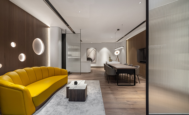 
会客区
Office lounge area

呼应办公室设定在海滩的情境，会客区立面点缀大小各异的圆形孔洞，描摹水气瀰漫的样态，中央茶几作爲原石意象的载体，设计为多边弧角的奇趣造型，地坪铺设的地毯借喻为白色沙滩，塑造一股静谧惬意的海岸氛围。实木色系与白色构筑的视觉画面中，摆放亮黄色沙发，为空间注入缤纷的活力色彩。

To meet the studio design theme of setting a beach-like situation, we hollow out a few vary-sized circles of the reception area facade to represent bubbles in the water. Then, place a striking geometric-shaped coffee table to signify a natural stone. In addition, lay an area rug to imply a white-sand beach, brilliantly creating a peaceful and pleasant coastal vibe. To the last, arrange a bright yellow sofa amid the situation finished with solid wood and white tone, injecting a vibrant color into the space.
