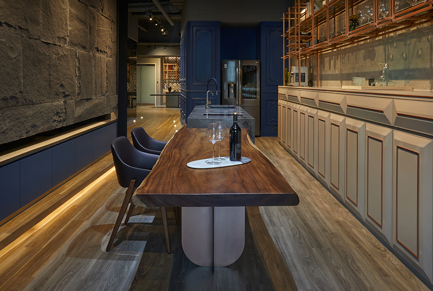 品酒空间 Wine-tasting area

品酒空间中，一片木作柜体铺展开来；油漆喷涂、内崁喷漆金属条点睛，奶茶色的基调，浅明中带有新古典的风味，其材质属性与上方展示柜相呼应，明朗中以自有光泽为空间增色。

In the wine-tasting space, a row wooden cabinet of milk-tea tone and inlay striking metallic stripes; gently reveal the neoclassical charm. The material echoes the display shelves above that brings about the glamorous feature of the space.

大理石包覆，与展示柜下同材质的柜体，作为简易中岛，延伸与原木桌板衔接，后者搭配订製单点式桌脚，使得观感上厚而不重，有着稳重而令人安心的感受；典雅雍容的环境，令人静静沉浸其中，享受澹雅休閒时光。

The marble-clad island is made of the same material as the cabinets below the display shelves and interlinked with a solid wooden table. The table equip with a customized thick support, which conveys a stable and reassurance perception. Thereupon, people enjoy the laid-back ambiance peacefully amid the noble and elegant environment.

项目资讯

案名：沉色缪思
项目类型：办公空间
项目地址：台湾台中
设计团队：共构设计
项目坪数：58坪
主要建材：灰玻、氟酸灰镜、铁件、大理石、磁砖、PVC地板、喷漆、实木板、油漆烤漆

吴君星．黄惠婷
共构设计有限公司　
电话：+886-4-2359-2686
地址：台中市西屯区安和西路6号1F
信箱：gatherart@gmail.com
网址：https://www.elegant-popular.com/

OPEN Design动能开启传媒：http://www.openworld.tv/talk/