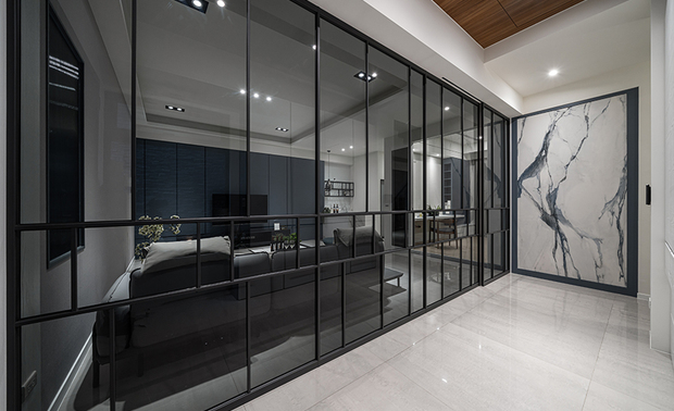 
玄关
Entryway

玄关廊道与视听室透过灰玻铁件立面及滑门作为区隔，其简约的玄色金属线条，刻画现代时尚意象，对侧灰白色木皮柜体，缀搭上方木质天花板，增添居者归宅时和暖柔润的感受。

The entrance corridor and audio-visual room are separated by a grey glass and metal partition with sliding doors, featuring sleek black metal lines for a modern and stylish ambiance. On the opposite side, grey and white wood veneer cabinets paired with the wooden ceiling above enhance the warmth and welcome for homeowners upon their return.

