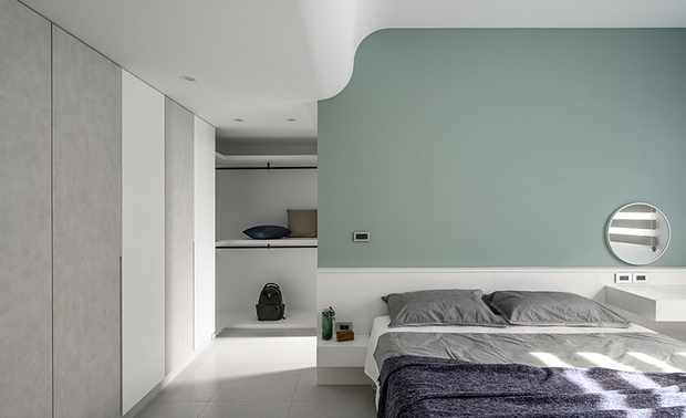 主卧
Master bedroom

卧室床背板与书桌一体成型，在色彩、材质方面呈现和谐美感，窗边另置入一座卧榻，让屋主于此享受惬意的阅读时光；角落的畸零空间打造为开放式更衣间，搭配订製的Ｌ型木作层板和挂衣铁杆，完善收纳功能。

The headboard equips a mounted desk, presenting an appealing, consistent look in color and material. In addition, set a window couch so the homeowner can enjoy leisurely reading time. Then, arrange an open-patterned wardrobe in the awkward corner, which equips tailor-made L-shaped wooden shelving and clothing hanging rods, skillfully improving the storage function.
