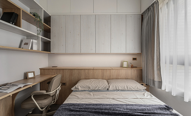 
主卧
Master Bedroom

主卧融汇书房及卧房，打造一处办公、憩息皆宜的舒适天地，同时延续居者对收纳的重视，床头由下到上分别设置矮柜、吊柜和叠柜，且于床尾的衣柜上方外加一层储藏柜，将充裕的储纳机能整合空间，兼顾实用与整洁。

A harmonious blend of a study and bedroom in the master suite creates a versatile haven for work and relaxation. Responding to the homeowner’s requirement for storage, we cleverly take advantage of the space to install the headboard cabinet, featuring low cabinets, wall-mounted cabinets, and stackable units. Additionally, above the wardrobe at the foot of the bed, an extra storage cabinet seamlessly integrates ample storage functionality into the space, providing a clutter-free and well-functioning room.
