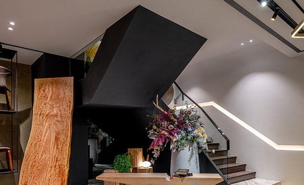 楼梯间
The staircase

通往二楼的楼梯，第一层踏阶加高、延展为一座展示台，用于摆放商品或造景；其右侧牆面设计为曲折的立体层次，并加装皮革扶手与灯带，引领顾客上楼，参观更加缤纷多彩的家具品项。

Elevate and broaden the first step of the staircase that leads to the second floor to fashion a display platform for placing commodities or creating a scene. The right wall is designed of a dynamic three-dimensional pattern; moreover, equip leather handrails and light strip to guide the customers to go upstairs to visit more colorful furniture items.