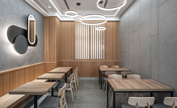
客席区
Dining Area

客席区规划四人座与双人座，中央採用灰色长型椅复合灰玻隔板，划分开放式的场域，不仅保留空间的通透感，也让两边的客人保有隐私，此外，回应业主对于原木质感的锺爱，特别于客餐区的尽头加入木质格栅与半腰壁板，营造圆润温煦的用餐感受。

We skillfully reconfigure the dining area for 2-seater tables and 4-person tables. Excellently place a long bench with the grey-tinted glass partition on the seat back at the center of the service area that can bring about unimpeded views and provide privacy for the diners on both sides withal. In addition, we moderately exploit the timber grid partition and waist-height wooden veneers at the end of the dining room to satisfy the proprietor's fondness and perform a warmhearted circumstance.
