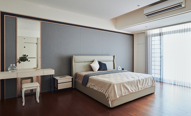 
主卧
Master Bedroom

主卧的浅色软装，与深木色地坪相互调和，配饰床头调性稳重的灰色壁布，共组一室温和的中性色彩，于侧牆衣帽间的暖光照拂下，形塑舒适的就寝氛围；床铺与落地窗之间，另预留空间作阅读区，供业主夫妻閒暇时休憩，或步至一旁的户外露台啜饮咖啡，共享两人时光。

The light-colored furnishings in the master bedroom harmonize with the dark wood flooring and finish the wall behind the bed with a calm gray wall covering, ingeniously adopting the mild neutral color schemes to bring about a comfortable sleeping atmosphere. Leave a space between the bed and the French window to utilize as a reading area; moreover, decorate the outdoor balcony so that the householders can enjoy sipping coffee and relaxing in their leisure time.
