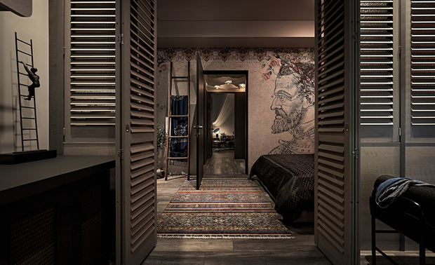 主卧
Master Bedroom
因喜欢民俗风元素和具历史感的老物件,因而运用地毯、壁画、家具,堆砌个性氛围。别于公领域的多彩纷呈,私领域以沉静暖调,回归休憩本质。木格栅门象徵着日常模式的转换——开门即上班、关门即下班,实现work at home的理想生活。
A deep appreciation for folk style and vintage items is elegantly expressed through the carpets, murals, and home furnishings, distinctly showcasing personal taste. In contrast to the vibrant communal areas, the private spaces have been adorned with soothing, warm tones, creating an ambiance of serenity and relaxation. The louvered bi-fold door symbolizes the transition between daily modes—opening it signifies the start of work while closing it marks the end of the workday—embodying the ideal of a seamless work-from-home experience.