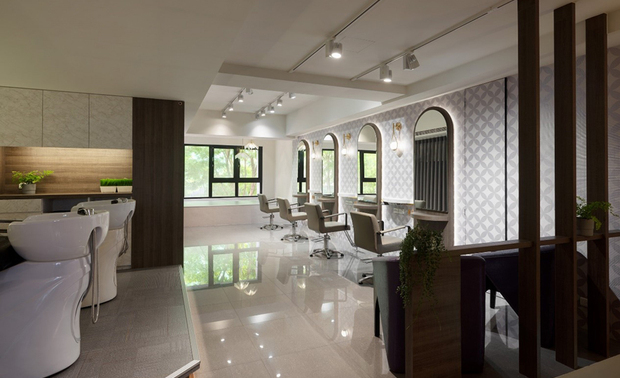 二楼工作区
Workspace-The Second Floor

相较一楼，二楼天壁藉白色降低存在感，同时做完善隔音处理，避免上方住家的声响干扰营业环境，而壁面选用半圆镜面、深色木皮和豆沙色壁纸，透过和楼下相同配置却相异的选材，塑造多变而优雅的空间。

We skillfully adopt a white hue to finish the second floor's ceiling and walls to distinguish it from the first floor. Its soundproof construction of perfection reserves a quality business space from noises caused by the residence above. Moreover, the arch mirrors, dark wood panels, and grayish-pink wallpapers compose the same staging as downstairs but from various materials. It is subtle to reveal a space in sophisticated transformation.

项目资讯

案名：光颖斜意
项目类型：商业空间
项目地址：台湾新竹
设计团队：巨设计集团–GD
项目坪数：38坪
主要建材：木皮、喷漆、特殊漆、金属板、明镜、壁纸、抛光砖、塑胶地砖


巨设计集团–GD
电话：03-6587330
地址：新竹县竹北市成功六街223号
信箱：dh@dh-design.com.tw
网址：http://www.dhia.com.tw/

OPEN Design动能开启传媒：https://www.openworld.tv/