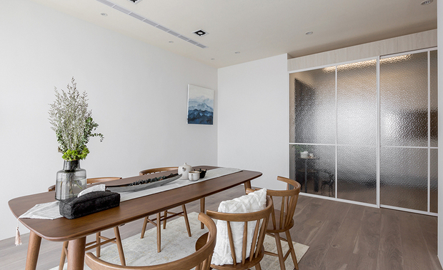 客厅
Living Room
作为亲子共读区,客厅划设整面落地窗,配合天花板多处的盒灯和嵌灯,确保孩童阅读时拥有充裕光线,也赋予身为教师的男主人可沉心伴同子女徜徉学海的清静天地,而足下舖设的米色地毯则携手桌椅的木质调性,进一步为此区挹注质朴柔润感受,彰显侘寂交融北欧风的天然气息。
The living room, incorporating light boxes and cove lighting, is designated as a child-parent shared reading zone with ample illumination. The calming vibe presents the home master as a teacher with an exclusive space to tutor his children. Besides, the wood table and chairs and beige rug cooperate to manifest a pristine Nordic character in a quiet approach.