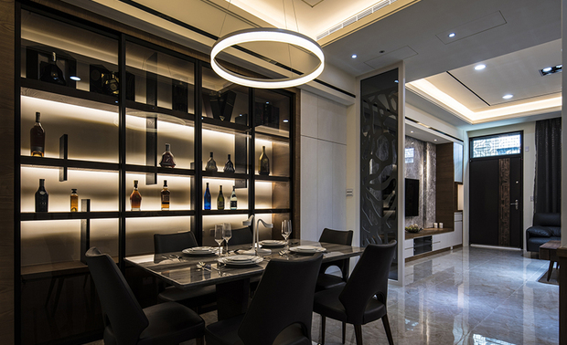 
餐厅
Dining Room

餐桌上方，悬挂造型简约的圆圈吊灯，寄託美好的「团圆」寓意；侧牆的大型木作酒柜，后方装设软条灯，渲染柔和光晕于业主珍爱的名酒收藏，其间错落的垂直层板，除了展现轻盈造型，亦兼作书挡板，可依不同时期的收纳需求，将此柜体转作书架。

Install a chic ring-shaped pendant light above the dining table to convey the beautiful implication of "Reunion." The large wooden wine cabinet on the sidewall features the homeowner's precious fine wine collection via soft wall washer lighting. The random vertical plates also serve as bookends and ingeniously transform into a bookcase to meet different storage needs.
