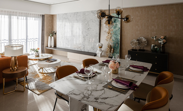 客餐廳
The living-dining area
 
公領域深窗結構的落地窗，為室內保留西曬的充足光源，卻不至燥熱，因此便利用這份優勢，選用暖色亮面的皮製沙發、餐椅，作為米色牆面的立體延伸，同時也和金屬壁飾一起迎接陽光，散發十足典雅的溫潤光澤與高貴情致；而電視牆旁的畫作，則在湖水綠的配襯下，流入一絲現代冷調，豐富畫面的風格與色彩。

The French windows of draw back structure in the public domain introduce plentiful sunlight, yet not too hot and dry. Therefore, the designer boldly selects the leather sofa and dining chairs of bright and warm tinge to set off the beige wall. The shiny decorations on the wall beneath the sunshine cast the refined and stylish texture. And the painting beside the TV wall of greenish-blue hue enriches the style and color of the space by means of the modern chilly tone.

