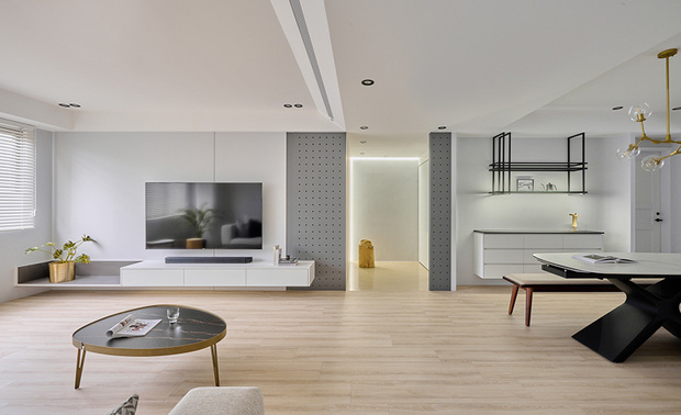 玄关、客厅
Entryway and living room

玄关区选用磁砖地坪，与其他区域的超耐磨木地板做出区隔，并在进门处设置如敞开大门的造型灰色洞洞板，塑造迎接意象，同时供屋主一家放置外出所需小物，一旁装饰线条的客厅电视牆，搭配下方块状分割的悬空柜体，两者在轻盈与厚实间达成和谐效果。

We pave the entryway floor with porcelain tiles to zone out from the laminate flooring in other areas. Then, install featured gray pegboards, which are handy for placing personal belongings. The concise TV wall in the living room assorts with the square suspended cabinet marvelously achieves a harmonious effect of lightness and solidness.
