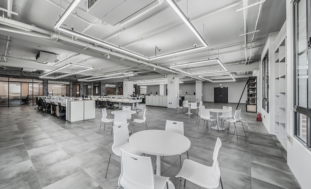 办公区
Open office area
与其他区域丰富的建材纹理不同,办公区以浅灰与纯白二色,营造明亮、清爽的工作环境;配合未经修饰的裸露管线,天花板悬吊铁件方框及LED灯条,使照明机能成为线性设计的元素之一,而休息区一侧的牆面,则善用其内凹结构设置收纳柜,供员工存放大量资料。
Unlike the diversified texture areas, we adopt the light gray and pure white color schemes to set the office area to create a bright and cheerful working environment. Then, we present feature elements of linear design with the original exposed ductwork, square-shaped ironworks, and LED strips on the ceiling. After that, take advantage of the concave structure of the sidewall at the rest area, set up built-in shelving so that the employees can pile up lots of documents.