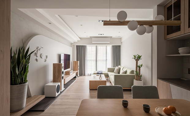 本文由OPEN编辑部撰写

设计概念 Design Concept

空间以纯白画布为基底，在木质笔触搭佐灯光软件下，一幅温润美好的家景应运而生。作为预备的新婚房，棠禾设计 曾智和 设计总监 希望以简单舒适为主要核心，给予更多空间，放入屋主喜爱的物品，能随时依照喜好和需求，做弹性变动。风格上依循屋主的喜好，公领域的部分，採日式无印风格，私领域为北欧简约调性，整体色调柔和相融，让休憩本质最大化。为避免空间视觉过于单调，也呼应业主活泼的性格，我们在天花板及门片上，做了细微的变化，既有点缀效果亦不显突兀——让设计融于生活，让生活贴近舒适。

The space is like a clean canvas. A warm and beautiful home scene comes into being through the wooden elements and glamorous light fixtures. Tang He Design design director TSENG CHIH HE accentuates simplicity and coziness to design the house for newlyweds. For instance, arrange sufficient spaces for the homeowner to organize their favorite objects by needs. And in the shared domain, we adopt a Japanese-Muji style and opt for a Nordic-Simplicity tone in the private area, successfully fulfilling the homeowners' preferences and creating a relaxed, harmonious situation. In addition, we decorate the doors and ceilings with refined moldings and trims to avoid monotonous perception and please the extroverted owner, brilliantly integrating the design with life and bringing a comfortable lifestyle.

设计手法 Design Techniques

跳色处理 视觉新意
Flash color schemes bring about creative visual effects

因应屋主喜爱的无印风格，全室选用淡色木纹搭衬浅色家饰，当柔光洒落，柔和恬静的氛围，浸润一室。我们透过牆面跳色的方式，在同质调的空间中求变化——客厅天花板及牆面皆为纯白色油漆，于是电视牆的部分，便採用浅灰涂料，注入一抹个性。卧室牆面及柜体，亦做跳色处理，增添视觉巧思，让看似平凡的休憩空间，多了一丝新意。

We opt for pale wooden grain materials and complement pastel-colored home decors to succeed in the owner's favorite Muji style. And, when soft lighting illuminates the overall space, it is full of a tranquil atmosphere. In addition, we apply contrasting colors to present various appeals to the same-textured surroundings. For instance, finish the living room ceiling and interior walls with pure white paint but apply light gray coating on the partial TV wall to enhance the distinctive feature. Also, the walls and cabinets of the bedrooms adopt an identical flash color scheme, which brings innovative touches to the homey resting space.

线条层次 营造律动
Smooth linear patterns generate vivid flowing rhythms

在20坪大的空间裡，我们希望彰显简约大气的质调，因此在「天花板」的部分特别着墨——客厅及餐厅过渡区域，以高低层次的方式，放大空间视感；电视牆作为家的端景，透过大片圆弧收边，清朗气质流淌而下；卧室天花板的弧线设计，亦遥相呼应，整体场域形塑一种流畅的律动，丰富了空间视觉。

We hope to manifest the simple yet grand imposing layout of the 66 square feet project; accordingly, we pay much attention to designing the ceiling patterns. We set a layering-shaped ceiling to create an extended feeling in the transition between the living room and the dining area. Then, set up a sleek curve-trimmed TV wall that perfectly serves as a striking focal point of the house. Moreover, the arc pattern ceiling in the main bedroom seamlessly echoes the design themes. Thence, we create an unimpeded situation and delightful views of the whole space.

形随机能 量身定做
Tailor-made settings satisfy the required functions

考量屋主的使用需求，我们在柜体设计上，皆量身打造；一部分是为了满足机能，另一部分则是希望跳脱既有框架，在形体上做变化。玄关区域的大面壁柜，採悬空设计，除了让整体视觉较显轻盈，同时方便扫地机器人的进出和收纳；镜面旁的柜体也做了微幅抬高，兼具衣物放置及穿鞋椅功能。餐厅和卧室的边柜，在储物之馀，利用线条及色调增添些许趣味。

To think out of the box, we design customized functional cabinets to meet the homeowners' needs. First, set up a suspended large-scale cabinet in the entryway to achieve a lightweight visual effect and also facilitate the sweeping robot to work. Then, slightly raise the open cabinet next to the full-length mirror to shape a platform for wearing shoes. Furthermore, arrange a sideboard in the dining area to place kitchen utensils and add fancy touches via glamorous lines and shades.
