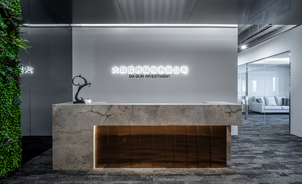 
接待柜檯
The reception counter

接待柜檯作为企业的门面，必然需要让人留下深刻印象，
针对项目为专业的投资公司，我们将前景定调为
典雅大气及沉稳精炼的简明语彙。
主牆捨去繁复装饰，採以背光投射公司LOGO，
让视觉焦点落在柜檯及天花板上；
金属质感的光线色泽，与石材纹理的澹雅柔和，
形构层叠交错的鲜明对比。

并在临侧牆面构筑一道植生牆，
选择以绿意作为色彩的点缀，
同时平衡区域的温度与视感，
亦展现企业永续经营的美好寓意。

As the front image of an enterprise, the reception counter must be impressive.
In view of the project is a professional investment corporation; the designers set the prospect of distinguished, elegant and concise elements.
The main wall did away with the complicated decoration, inset the backlight to reflect the logo of the company, so that the vision would focus on the counter and the ceiling.
The gloss of the metallic looks is in sharp contrast to the mild texture of the stone.

Besides, erect a vertical garden on the sidewall, the greenery plays the role of the color embellishment, which balanced the temperature and visual sense of the area at the same time, and shows the well wish of sustainable operation of the enterprise.

