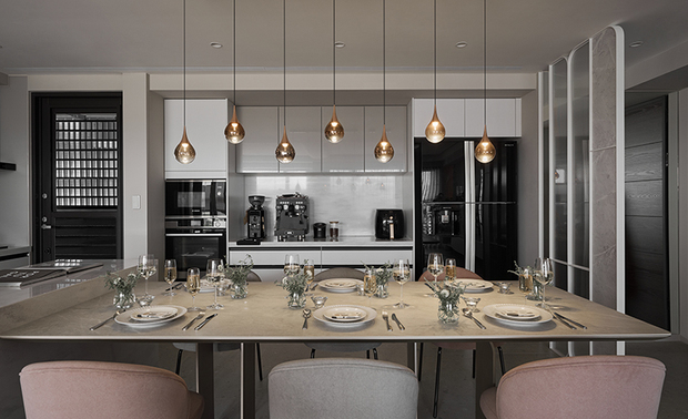 
餐厨区
Kitchen & Dining Space Combo

配合业主接待访客的需求，餐厅选配多人长桌，搭配灰、粉相间的麂皮餐椅和玫瑰金泡泡吊灯，呼应整体色调及现代风格，营造充满仪式感的用餐氛围；厨房则安排中岛、流理台和电器柜，满足使用者备餐机能，构筑宾主尽欢的聚会场域。

Considering the homeowner’s requirements for entertaining guests, we arranged a large dining table serving more people. With matched suede chairs and golden drop pendant lights, the trendy dining space creates a sense of ritual in the dominant color palettes. Besides, we built a functional kitchen that incorporates an island, sink units, and electric appliance storage to facilitate food preparation. It is successful in accomplishing a statement gathering space.
