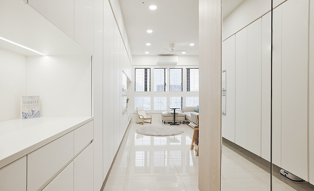 玄关
Entryway

玄关左侧为一整面连结至客厅的大型收纳柜，中间镂空部分作平台，减缓入口画面的压迫感，且可放置出入家门的必需品或展示照片；右牆面则装设大片镜面，遮挡电錶箱之馀，亦有放大空间感、整理外出仪容的功能。

A generously sized storage cabinet adorns the left side of the entryway, seamlessly connecting to the inviting living room. The center is artfully designed with a countertop, alleviating the oppressive, cramped feeling and providing the perfect place for essential items by the entrance or displaying cherished photographs. On the right, a large expanse of mirrors ingeniously conceals the electrical panel and creates a sense of amplitude, doubling as a convenient spot for final grooming before heading out.
