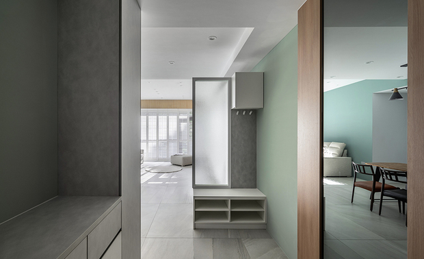 玄关
Entryway

玄关以系统板材打造多功能隔屏，并採用订製雾面边框包覆水波纹玻璃，呈现隐约透光的朦胧美感，同时化解风水疑虑，并结合开放式柜体与挂钩，可摆放室内拖鞋、外出衣物及配件，满足进出家门便利性。

We utilize system panels and a customized matte aluminum-framed figured glass to set up a multi-functional screen at the entryway, presenting a gossamer beauty of light and shadow and artfully resolving geomancy taboo. And assort with an open cabinet and hooks for placing indoor slippers, outdoor clothes, and personal items, successfully meeting the convenience of entering and leaving home.
