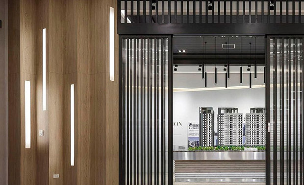 
接待中心
Reception center

作为访客进入接待中心的首要区块，天花板的六角形块状灯源，丰富高低层次，以跳脱寻常造型的样式，予人活力多样性的感受；左侧设置于视听室与展示区外部的木质镶嵌灯带，则成为柜台旁的端景牆，藉由直立线性的排列，创造层叠大气感。

The hexagonal-shape lighting fixtures on the ceiling of the reception center, which depart from the conventional design to enrich the layering interest of the guiding area, sharply favor the visitors with a distinct vibrant feeling. And, around the front desk, the massive wooden settings equip brilliant recessed strip lights, which bring about a cascading grandeur look and strikingly serve as feature walls by way of vertical arrangement.
