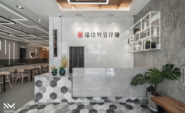 ▲接待区铺陈復古的六角砖并向上延伸至柜檯，另叠加纹路细緻的大理石材，搭配一旁俐落的铁件层架与别具一格的造型logo牆，为延续二十多年的传统美味添入新气象。
