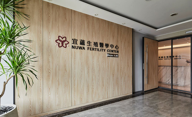 本文由OPEN编辑部撰写

设计概念 Design concept

生命交织，共舞绽放
In bringing hope and vitality to newborn life

彷若花朵含苞待放，新生的气息由线、面带领，敞开大门而入；知晓医学中心的本质，简兆芝室内设计 简兆芝 主持设计师 以澹雅的质材、软装，谱奏柔美且令人安心的设计篇章，使医疗人员得以顺利执行任务，展开双臂，引导女性踏上成为母亲的旅途。

温暖如春阳，广阔如汪洋，是幼孩出生的宁静所在，明亮、温馨，呼应新生儿来到母亲的怀抱，吐纳最初的新鲜气息；轻柔奔放的圆弧，将女性孕育生命的身形曲线，形塑于空间的舞动，拥抱每位心怀迎接生命的到访者。

于圆满丰实的线条之中，勾勒出迎接生命的盼望，根据酒红点以粉红的商标，与温柔清新的专业形象，佐以木质纹理，融合天然环境，在自然与人工交织共舞之下，表露初生的气息，创造柔美恬静的舞动绽放画面。

INK DESIGN SPACE presiding designer Kathy Chien exploits elegant elements and furnishings to fulfill a gentle and reassuring design that meets the essence of the medical center. The newly born ambiance as if the flowers revealing the new growth. Hoping the agreeable configuration can help the medical staff to accompany with women on their journey of becoming a mother.

A bright, cozy, tranquil circumstance warmheartedly receives the newborn baby comes to the mother's embrace. We borrow the pregnant women figures and transform them into gentle and unrestrained arc lines to finish the interior setting marvelously bring about the lively vibe of the space to greet people who welcome the just born baby with heart.

The logo of burgundy-pink colors on the natural wood veneer wall skillfully manifests the gentle, refresh, and professional image also creates a soft and peaceful appealing scene of welcoming new life.

设计手法 Design Techniques

序列手法 妥善引景
Adopt the sequential approach to configure each functional area

为使就诊者得以安心谘访，空间以序列性手法规划延伸，将等待、谘询与问诊的区域划分为敞亮、隐蔽，再到开放的形影交错形式，由温馨的粉色系软装、外部自然景观和光线的连结，创造户外区的悠閒景緻，而当场景过渡到相对私密的就诊场所，则不做对外採光；与之对比，问诊处引入外部灯光，离开原先的封闭感受，在区域的切换之间，细心考量到访者的心境。

We adopt a sequential approach to plan the space, where carefully divides into a bright open-patterned waiting area and a secluded consultation area so that people can feel at ease. For instance, we arrange cozy pastel furnishings and introduce natural sunlight to create a comfy relaxing situation in the waiting area. Then, in the relatively private consultation space, we charily plan an enclosed layout to soothe the clientele's worries.

遵循医用 便利操作
Comply with the medical conditions to plan trouble-free settings

因为此处属医疗场所，为使实验室中的培养箱及周遭环境，具备高度洁淨性，在医疗区天花板与牆面，使用环保无甲醛的波音软片取代油漆，并顾及医疗人员使用便利性，採用脚踩感应的自动门片，即使手上持有物品，也能便利进出。

We meticulously make use of PVC films of eco-friendly and formaldehyde-free features instead of paint to set the ceiling and walls of the medical center to create a highly clean environment for the incubators in the laboratory. And in consideration of the convenience of medical personnel, we equip foot-operated, sensor-activated automatic doors to facilitate entry and exit even with objects in hands.

延续风格 恆久维护
Exploit well-qualified elements to meet the long-term maintenance demand

由于场域需每日以漂白水消毒，室内广泛铺设以塑胶高温压缩製成表面材质、木纹质感的石塑木地板，搭配耐久性优于壁纸、好擦拭，具有纹理的壁布，和採用在等待区的绷皮革加上泡棉，不易受损，也可维持整洁度；此外，桌面使用较环保的薄板作为材料，其耐酸硷度的特性，也符合医疗用途，兼及长久利用与维护的效用。

Since the whole circumstance needs to be disinfected daily with bleach, we take advantage of the veiny laminated flooring, durable wall cloth of excellent wiping features, and not easily damaged leather foam to uphold the standard of cleanness. In addition, exploit eco-friendly stone slabs for the countertops, which are resistant to acid-base and meet the medical utility of long-term performance and maintenance.

活化诊所 平衡空间
Coordinated layout and illumination arrangement excellently activate the clinic vibe

除天花板与柜台边角，以女性怀有新生儿的肚腹轮廓线条勾勒，依循生殖中心结合自然与人工，进而创造孕育出新生命的本质，交错呈现自然天光与人造灯光，活化场域氛围，避免医疗场所的冰冷气息。

涵盖于曲线、灯光的设计之中，秉持设计长久以来的「平衡」设计理念，「匀称」的视觉感被带入空间，凭藉软装、硬体色彩的安排，呈现粉色与灰色的中和、材质的交相辉映，表露澄澈舒适的画面。

As per the nature of the fertility center of combining the natural and artificial methods to nurture new life, we introduce natural sunlight and crafted lighting fixtures to energize the atmosphere of the domain, further, abstain from the frosty clinic ambiance.

We adhere to the long-held design concept of "balance" and ingeniously bring the "symmetrical" visual sensation into space through the wavy linear pattern and lighting design. The neutral pastel interior furnishings and selected materials brilliantly accomplish an airy and homely circumstance.