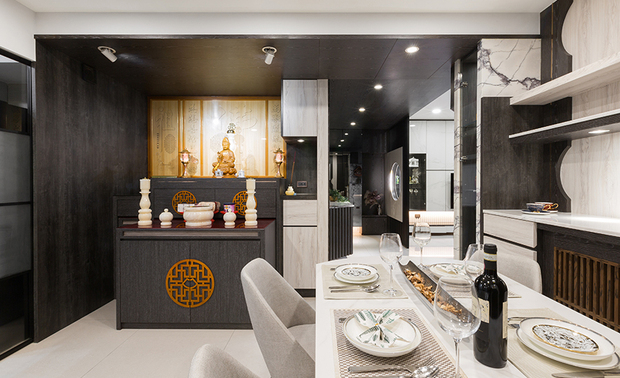 
餐厅
Dining area

沙发背柜的大理石延伸至餐厅酒柜，一旁立面则以松木和白木纹为基底，採用镀钛缀于其中，形塑不规则的圆弧造型，呼应玄关屏风与一旁神桌的佛教意象，并作为廊道尽头之端景牆，同时将收纳巧思汇入其中，再次展现生活机能与空间设计之美。

Exploit the same marble slab of the cabinet behind the living room sofa to set up a wine cabinet in the dining area. Then, finish the sidewalls with black and white texture pine wood veneers. Moreover, decorate them with titanium-plated trims and asymmetrical arc patterns to correspond to the foyer screen and Buddhist implication. At the same time, it serves as a feature wall with stow spaces, ingeniously realizing the glamorous and feasible design.

