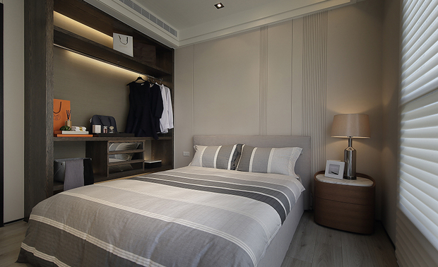 主卧
Master Bedroom
承续公领域低调简约的风格,主卧床背牆与尾牆皆施以米白色烤漆,搭配丰富线条,打造简练的现代风范,并延续相同基调,佐搭冷色调的条纹寝具,另于两侧置入暖色木质柜体与床头柜,在一旁丝柔百叶窗帘的自然光晕下,相互调和衬映,共筑温厚和谐的安眠场域。
Continuing the understated minimalist style of the public area, we finish the walls behind the bed and at the end of the bed with baking enamel paint. With plenty of clean strings, the wall coating reveals a modern vibe. To cohere the color scheme, the cool-colored striped bedding, the warm wooden cabinets, and the nightstand harmonize with the natural light through the filmy Venetian blinds. They cooperated to create a balmy and tranquil sleeping zone.