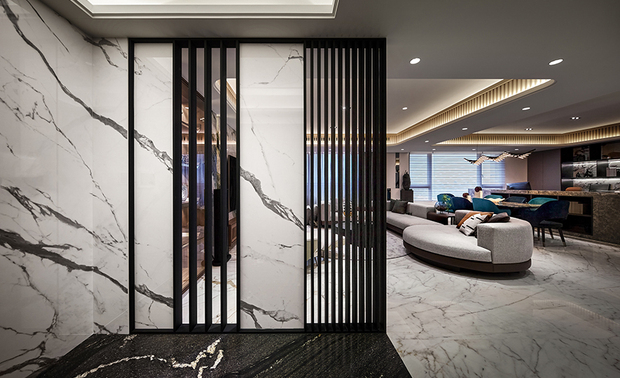 
玄关
Entry Foyer

为了兼顾宽敞感与隐私需求，玄关屏风的石纹大板砖嵌入两座铁件格栅，相异的间隔距离形成远近错落的视觉效果，而地坪则选用带有金色花纹的黑色大理石，使两者色彩相呼应。

Artfully install two iron grid partitions among ceramic panels with stone grain to leave the private space, and visually expand the placement via asymmetric intervals within grids. We exploit the black marble with golden veins as foyer flooring to work in concert with the color scheme.
