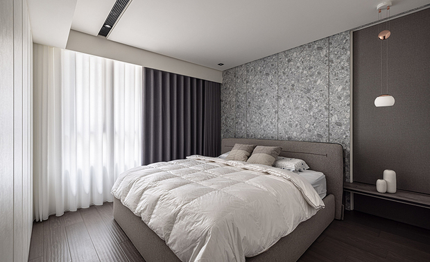 
主卧
Master Bedroom

承续公领域的沉稳基调，主卧选用石纹清晰的床头壁板与灰棕色布质床架，共组深沉的睡眠环境，窗畔搭配双层遮光帘，让屋主自由调控进光量，营造光耀明媚抑或幽静宁谧的休憩氛围。

The master bedroom features a bedhead wall with distinct stone patterns and a sophisticated taupe upholstered bed frame to carry on the composed ambiance of the shared areas, bringing a serene and comfortable sleeping environment. The window is adorned with double-layer blackout curtains, allowing homeowners to freely adjust the incoming light, creating a space that can be either brightly illuminated or peacefully secluded for restful moments.
