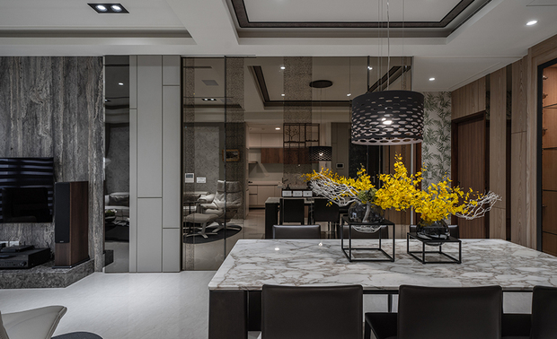 
餐厨区
Kitchen & Dining Area

延续厨具的木纹元素，餐厅选用木质餐橱柜，替场域增添温润暖意；厨房对侧规划复合茶镜及彷古镜的滑门，丰富立面层次，中央则置入业主挑选的石纹餐桌，搭配黑色皮革餐椅，营造俐落不失温馨的用餐环境。

Arrange a woody sideboard in the dining area to continue the wooden approach of the kitchen and bring a balmy vibe to the field. And on the opposite wall, we installed a sliding partition assorted with tinted glass and antique mirrors for layering the facade. The homeowners select a stone dining table at the center spot with black leather chairs to appeal to a nifty and warm dining space.
