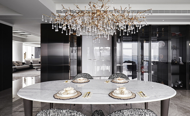 餐厅
Dining room

餐厅透过绚丽大气的吊灯，在夜晚呈现温馨的光线氛围，并与绿色吧台椅一同跳脱澹雅的空间基调；角落设置纯黑展示柜，突显业主收藏的白色陶器，同时延续入口木皮格栅的深色元素。

Install a gorgeous chandelier in the dining room to bring a homey vibe at night, and place two blue-green bar stools to set off the elegant base tone. Set up black built-in display cabinets to show up the homeowner's white pottery collections while corresponding to the atramentous wooden grille setting at the entrance.

