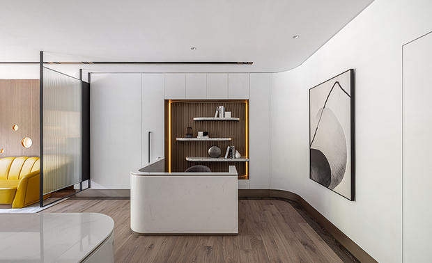 
本文由OPEN编辑部撰写

设计概念 Design Concept

踏进位于市区的办公室，恍若来到一望无际的海滩既视感，自天、立、地面到家具软装，连结随着浪花翻滚而上的白色原石，且经过岁月层层剥开朴实的外表，显露出耀眼金色光芒，以及完美的纹理，展演出品牌的天然个性美质。

峥嵘设计 廖峥 廖嵘 设计师 藉由开放的场域规划与落地窗，营造宽敞明亮的视觉感受，并结合木质、简洁线条及自然光线等元素，形塑现代简约、北欧纯粹的复合风格，而立面粉刷纯白的乳胶漆，铺设间隔透光的实木格栅、暗金色美耐板，搭配硬软装的弧状曲线，则表现为公司精神的原石象徵，流露踏实循序的设计性格。

Stepping into the design studio amid the hustle and bustle of urban seems like situating the relaxed seashore. The ceiling, interior facades, flooring, furniture, and furnishings artfully manifest impressive features and glamorous textures through simple patterns. Thereupon, reveal the down-to-earth ethos of the design studio.

C. J. HOUSE DESIGN designers Cheng Liao and Jung Liao carefully plan an open space with large French windows to create a roomy, bright visual effect. Take advantage of wooden elements, concise linear features, and natural lighting to fashion an eclectic style of Simple Modern and New Nordic. Coat the walls with pure white latex paint; set wooden gratings and dark blonde laminated skirting boards; arrange arc-shaped soft furnishings, ingeniously signify the earnest, well-organized principles of the design studio.

设计手法 Design Techniques

原石意象 蕴藏光彩
Natural stone features contain glamorous brilliance

建筑外观、茶几、收纳柜与接待柜台区半牆的石纹质地，以及壁面的洁白色彩，将空间的硬软装，形塑为海滩原石的样貌，而立面的实木皮与实木格栅，拟作石头层理，结合线形灯、美耐板光泽，使内部隐约透出灿烂光辉，阐述映射天然美质的品牌底蕴；木质建材搭配实木地坪，藉由直线纹路，传递有条不紊的品牌特质。

The marbling texture of the exterior appearance, coffee table, storage cabinets, and half-height partition is in tune with clean white interior walls. The interior finish and soft furnishing artfully appear for natural stone features. In addition, we opt for solid wood veneers and gratings to finish the interior facades and assort with a linear shape light fixture and glossy laminate sheets, gently bringing out the exceptional brilliance of the space and carrying out the true inner beauty of the design studio. And the straight-linear-patterned solid wood floor conveys the studio's well-organized trait.

勾勒圆弧 环节相扣
Circular arc settings with concordant details

天花板衔接立面处与灯沟，以及梁柱、办公桌、茶几和角落展示柜，皆採用圆弧元素，呼应空间主轴的天然原石曲线，而会议桌上方的吊灯、讨论区角落的落地灯，更透过不同形式的圆形、弧线造型，一同串连整体丰富的视觉设计。

The connection of the ceiling and interior walls, recessed light grooves, meeting desk, coffee table, and built-in shelving all contain arc features, skillfully corresponding to the design theme of natural stone shapes. And then, take advantage of vary-shaped fixtures, such as the pendant light above the meeting desk and the floor lamp at the corner of the negotiation area, brilliantly showing the striking visual design.

简约佈局 空间明朗
The simple layout results in a breezy, well-lit space

办公室规划为开放式格局，呈现宽敞的视觉感，且将空间重点的讨论区划分一侧，另一侧并排会客区、接待柜台区，再以铁件外框的长虹玻璃屏风，间隔不同功能区域，整体规划自然流畅的动线，并透过落地窗，将白天阳光引入室内，夜晚则以嵌灯局部照明烘托氛围，搭配吊灯、线型灯、落地灯各式光源增添亮度。

We design an open-patterned office to create a spacious situation with smooth flows. In particular, separate the negotiation area from the office lounge and reception areas. Then, erect an iron-framed figured glass screen to divide different functional areas. Introduce brilliant daylight indoors through the large French windows; while setting off appeal vibe via recessed lighting at night. Furthermore, install varying light fixtures like the oval ring hanging lamp and the trendy floor lamp to improve brightness.
