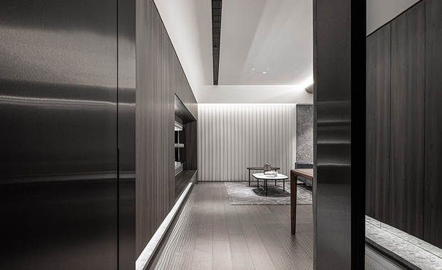 
玄关
Entryway

玄关採用黑色不鏽钢拉丝金属柜门、灰镜，呈现延伸空间之效，并与玄色镜面外观的电子衣橱相映衬，足下铺叙深色石英砖地坪，形塑和谐一体的深邃画面，期许屋主回家后能摆脱外界纷扰，进而沉淀放鬆，呼应此处「落尘」之含义。

The entryway features black metal cabinet doors of stainless steel brushed and gray-tinted mirrors that visually enlarge the space. The sleek black mirrored steam closet harmoniously complements the overall aesthetic. A deep-colored quartz brick flooring lies beneath the feet, gently performing a cohesive look. We sincerely sought to realize a tranquil haven that works in concert with the essence of the drop zone, for homeowners to leave the hustle and bustle behind and find serenity.
