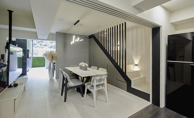
餐厅、游戏区
Dining Area & Play Space

餐厅延续现代风格，置入白石纹长桌搭配曲线吊灯，形塑简约时尚氛围，并于游戏区交界设置旋转电视柱，令用餐或游憩时皆可观看。

The dining area seamlessly extends the modern design theme. A long white marble-patterned table, complemented by a curvaceous pendant light, elegantly results in a clear-off and stylish circumstance. At the border of the dining and play area, we cleverly exploit a rotating TV column, allowing for viewing whether you're dining or relaxing.
