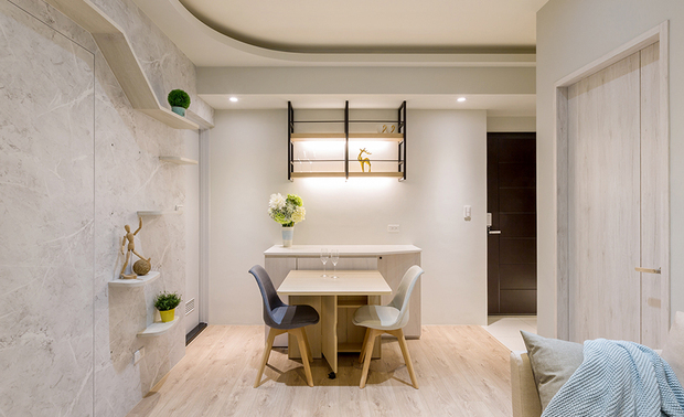 餐厅
The dining area
为方便客人走动,靠牆的餐柜,可收纳旋转餐桌与多张椅凳,并将近门一侧的柜角斜切,使量体不会过于方正笨重,其上方由温润木质与暖系灯带组成的吊柜,则供屋主摆放各式名酒,大小适中的护栏隔间,既兼有展示功能,亦可避免好动的毛孩碰撞。
A swivel table and chairs can store in the tableside cabinet to make smooth flow for the guests, and shape the side close to the door of beveled pattern to make the cabinet body not too squarely and bulky. The hanging cabinet above is composed of balmy timber and warm light bars, which for the homeowner display his fine wine collections. The decent-sized guardrail not only helps to show off but also prevents the collision from the fur kid.