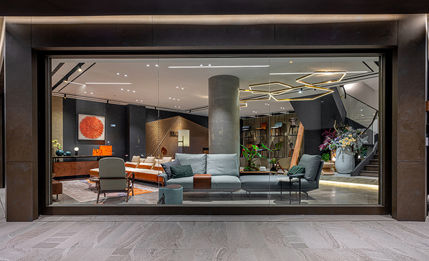 一楼展示区
The showroom on the first floor

一楼展示区同为店舖的门面，因此其三面外牆皆开大片落地窗，内部陈设的精美进口沙发，除展现品牌气度外，也特别选择不易相互遮挡的低背造型，维持画面的通透敞亮；入口上方垂挂一排五角形吊灯，作为迎宾指引，一路导领客人至柜檯，享受最妥贴完善的服务。

The showroom on the first floor serves as a glamorous storefront; make use of three large-scale French windows to reveal the temperament of the brand. And then, particularly select exquisite low-back imported sofas to keep the transparent and bright situation. At the entrance, install a row of pentagonal stylish light fixtures to guide the guests to the reception counter, happily enjoy the most considerate service.
