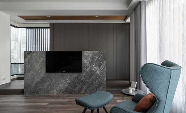 
主卧
Master Bedroom

思及住者锺爱现代元素，主卧採用深灰床背牆与分割线条，传递恬谧内敛的沉稳氛围，配合澹色调寝具，¬调和深沉暗色，打造自在的舒眠场所，另考量业主收藏香水、香氛蜡烛的习惯，将一旁壁柜转角规划为开放式层板，兼具收纳与展示珍藏品之用，对侧的大理石电视牆后方则加高地坪，并设计木质天花板，替场域增添温馨暖意，辅以后方灰色滑门，迴避窗对格栅的风水疑虑。

Taking into account the residents' love for modern elements, the master bedroom features a deep gray headboard wall and dividing lines to convey a sense of serenity and reserve. The light-colored bedding is paired with deep colors to create a comfortable sleeping space. Considering the owner's habit of collecting perfumes and scented candles, the corner of the wall cabinet is arranged as an open shelf to serve as a storage and display for the collections. On the opposite side, the marble TV wall is raised and designed with a wooden ceiling to add warmth and coziness to the space. The gray sliding door at the back is specifically designed to avoid any feng shui concerns on window grilles.
