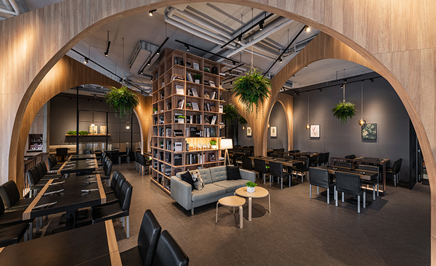 本文由OPEN编辑部撰写

设计概念Design Concept

业主希望品牌定位能予人温馨及归属感，创造明亮又如家舒适的温暖空间，由此设定发想，清筑设计 许清皓 设计总监 依循量体形构，「城市中的祕密花园」概念成为设计核心画面。予人别有洞天之感的场域，好比隐密的花园图书馆，各个角度的环境气质皆有所不同，使人行走其中时感到移步换景。

以自然、流动的氛围塑造为目标，沉静的书香气息，配以绿植点缀，透过情境的经营、拱形结构及矮隔屏的穿插，诞生使来往客人具心理隐密性的沉淀之地，将店家由先前的封闭式包厢隔间，转型为开敞弹性、具视觉穿透感的饮食殿堂。

The proprietor wishes to set the brand of amiability and loyalty image, and bring about a bright and cozy homey space. On that account, CC Interior Design chief designer CHING HAO HSU besides to comply with the site structure; the notion of how to construct " a Secret Garden amid the City" becomes the hub of the design scheme. Looking forward to create a cave paradise that looks like a private garden library, and possesses different features of each corner, hence to provide glamorous scenes of the domain.

We aspire to bring about the nature and vivid atmosphere, moreover, to plan the serene literary setting in the meantime. In view to achieve the goal, we meticulously decorate by means of the green plants; diligently arrange the circumstance by way of the arch-shaped structure and the low screens, hence, set up a mellow space of freedom from interference. Thereupon, successfully transform the previous enclosed compartment pattern into a capacious and see-through palace of dining.

设计手法Design Techniques

善用量体形构 焕发空间本色
Take advantages of the original structure of the site to shine the spatial features

由于量体本身即为挑高空间，又具方正格局、大面积的对外落地玻璃，採光上的优势替场域明朗增色的同时，在形塑温室氛围上更是相得益彰；天花板高度切齐落地窗，内部隐藏杂乱管线、阻隔建物顶层铁皮的热度，顾及机能以及美观考量。

Take advantage of the open and square pattern of the structure to create the spatial feature, moreover, the large-scale French windows excellently introduce the sunlight, in addition to bright-up the space, but also bring about the vigorous ambience as well. The ceiling height is flush with the French windows, hence well conceals the disordered pipelines and obstructs the heat from the iron sheet of the roof. Consequently takes the function and aesthetic into account at the same time.

巧设弧形拱状 落成殿堂景观
Ingeniously set up the arch-shape pattern to present the palace view

拱形设计为古典建筑中常见的语彙及意象，运用在现代场景中，使线、面生成在斜面交错的室内，使得身在其中，宛若置身洞穴，以不完全具体的隔间方式逸散似有若无的空间气质；静坐用餐时能达到心理上与他人的区隔，穿梭之间则能感到当中人与人间未完全隔断的相连性，兼具隐密性及开放性。

The arched design is the accustomed element and feature of the classical architecture, yet we exploit it for the modern layout. The interweaved curve-lines and sides, which make people, feel as if in the gallery. Further, by way of the semi-partition to bring about the one and only atmosphere, and as well to keep the privacy while dining. On the other hand, people can still enjoy the connections while in the same space. Thereupon, perfectly unite the tranquil and transparent setting.

人文书香溢室 景人相映增色
Convey abundant humanistic and literature implication amid the whole space to generate the captivating charm

位在楼梯间及餐席区的大面书柜，使沉静分子恬静幽雅降临，楼梯部分的书柜为食客来访时，进入眼帘的第一画面，在初始印象便予人惊豔感，独特的神秘感吸引观者，使人产生一探究竟的欲望；二楼高度设置的中空景观口，除作为用餐者与外界的软性分隔，使空间裡外有所互动关联性，用餐者作为窗景的一部分，享用餐点的同时又被观看，有人景相映的奇趣，在视觉和心理上都饶富想像空间。

The large built-in bookcase is set in the stairwell and straight up to the second floor, which casts the serene and elegant factors. The bookcase shows the inviting feature of the first-sight to the space, the unique and profound perception attracts the people desire to explore. The pattern of the atrium of the second floor, which makes a distance of the diners with the exterior; on the other hand, people on the street might see the diners inside, so that the diners would become a part of the side-view, thusly form a fascinating contrast.