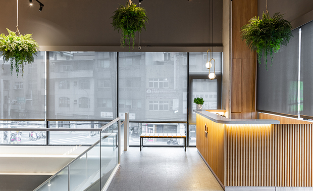 柜檯
The reception counter

长条造型木料拼贴搭配人造石材，为团队提出运用在此店面的设计，藉由木的温润、石的沁凉相构，搭配悬挂天花板及拱门柱体底的绿植点缀，使进入空间者第一眼便能感到自然平和。

The design team proposes to make use of long wooden bars and collage with the artificial stones to set up the reception counter. By way of the balmy sensation of timber and the cool touch of stone, furthermore, assort with the green plants hang on the ceiling and place at the bottom of the arch columns, accordingly bring about the nature and peaceful texture at the first glance.
