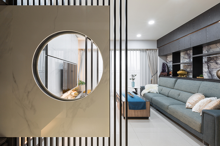
本文由OPEN编辑部撰写

设计概念Design Concept

柔和的环形光晕从屏风中流泻，与窗外和煦日阳相映生辉，犹如佛祖广纳世人的包容性，为皑白陶板与深褐木质晕染上温柔气息；信步入内，廊道转角处的神桌溢散红光，衬托佛像的庄严，诚心礼佛、摒却杂念，带着虔诚之心，安处于平静恬澹的生活场域。

艾美幸福设计 许捷甯 设计总监 将「禅」纳入空间的每个角落，巧妙地运用简约的黑、灰、白色建材，结合温润柔和的陶板、纹理大气的石材、坚硬刚强的铁件与质朴温煦的木质，彼此交融、互补，正如佛教所谓「因缘和合」，人与环境最终达至一个「圆满」的状态。

The soft circular halo flows from the screen and complements the warm sunshine. The white ceramic panel and dark brown wood grill setting represent the magnanimous tolerance of Buddha and emit a calm vibe. At the corner of the corridor, the home Buddhist shrine sets off the solemnity of the Buddha statue, the householders sincerely worshipping the Buddha, getting rid of distractions, and settling in a peaceful and tranquil situation with a devout heart.

Amy Studio design director Amy Hsu spreads Zen-like features around the space. Ingeniously utilize the simple black, gray, and white toned building materials, and assort with warm, gentle ceramic panels, glamorous textured marbles, steady vigorous iron parts, and rustic balmy timbers, which are well-proportioned and complement each other. Just like the so-called "Union of causes and conditions" in Buddhism, people and the environment eventually reach a state of "perfection."

设计手法Design Techniques

东方禅风 黑白沉静
The calm black-white tone reveals the Oriental Zen-like ambiance

考量业主的佛学信仰与喜好，全室色调以黑、灰、白作为基底，硬装选材从润白的陶板、黑白纹理交织的大理石，到深褐色的木质，用色与质地上相互融合，打造沉稳宁静的氛围，佐以灰蓝色系软装，为肃静的公领域增添自然气息，达至动静和谐之禅意。

Considering the homeowner's Buddhist belief and taste, we adopt black, gray, and white as the base tone. Select polished white ceramic panels, glamorous white marble with vivid black veins, and dark brown wood to fashion the space. Skillfully integrate the colors and textures to bring a calm and serene atmosphere. In addition, arrange mist blue home furnishings, which enrich a natural ambiance to the composed public area and achieve a harmonious Zen implication between liveliness and stillness.

陶石相间 遥相呼应
The splendid ceramic-marble patterns marvelously correspond to each other

结合收纳功能的电视牆，採用白色陶板作为柜门，轻巧、简约仍保有厚度的质感，能使门板五金长久使用；对面的沙发背柜，其后方立面为来自西班牙的大理石「纽约纽约」，由业主亲自遴选，带有强烈的线条与凋刻质感，即使作为柜体背景，仍不减其风华；两种建材相互应和、配置得宜，为公领域奠定和谐的主视觉。

The TV wall with a storage feature shows a lightweight and sleek pattern through white ceramic cabinet doors, which are excellent for long-term usage. Exploit a New York marble polished slab to finish the wall at the rear of the sofa, which is imported from Spain and personally selected by the homeowner. The glamorous veiny pattern becomes an elegant focal feature behind the wall-mounted shelves. The two well-arranged building materials marvelously complement each other, creating a harmonious situation in the public domain.

信仰中心 机能巧思
The crafted arrangement with unique features accomplishes the hub of family beliefs

位于餐桌斜角的神明桌，作为全家人的信仰中心，其文公尺的丈量、吉祥基数的讲究、收放自如的机能性到全手工木作，皆与业主、风水师讨论规划，由木工师傅打造出独一无二的神桌，不仅外观庄严肃穆，内部装置更为讲究，除了基础收纳空间，另将桌面设计为镂空造型，置入红色玻璃与间接照明，开灯后发散的红光可作为神明灯，使上方佛像更显庄重。

We meticulously discuss and plan with the proprietor and the geomancer, use the carpenter's ruler to measure angles, pay attention to lucky numbers and flexible functionalities, and masterly make a unique handcrafted home shrine adjacent to the dining table to serve the family beliefs. We set up a stately look and required storage spaces. Moreover, mount red-tinted glass on the hollow-patterned tabletop and install indirect lighting to serve as the Buddhist lamp, shining on the significant Buddha statue.
