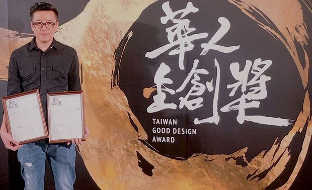 （图）戴总监第一次报名便收穫双件入围，在背板前面照相留念。