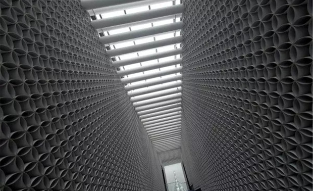 ▲图为：二楼洽谈区长廊部分
纸筒之间有序的楯接形成现代几何元素，通透而有趣。

这种神圣与世俗的强烈冲突，对于一个售楼会所而言却又合情合理。