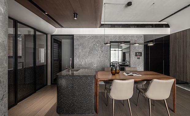 
餐厨区
Kitchen & Dining Area

餐厨区立面和过道延续客厅电视牆、沙发背牆的石纹元素，令视觉和动线顺其延伸，厨房内部按照食材储存、清洗、备料和烹调的顺序，依序安排冰箱、橱柜、流理台与瓦斯炉，另加入中岛平台作为额外洗涤及备餐的空间，使料理过程更加顺畅便利。

The design of the kitchen and dining areas extends the stone pattern elements from the living room's TV wall and the sofa's back wall, creating a visually cohesive and uninterrupted flow. Inside the kitchen, we meticulously follow the sequences of ingredient storage, washing, preparation, and cooking to plan so that the refrigerator, cabinetry, countertop, and gas stove are thoughtfully arranged in this order, with the addition of a central island to provide extra space for washing and food preparation, ensuring a seamless and convenient cooking process.

