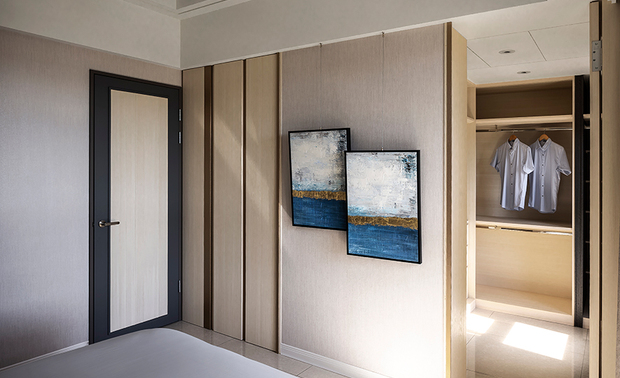 主卧
The master bedroom
 
因建物的结构横樑，造成主卧天花板高低落差较大，因此採用层层推进的造型修饰，保留空间原有的挑高特性，加上澹色的木纹牆与门片，共同围塑开阔和缓的休憩环境；在床具选配上，则用大抱枕取代床头板，不仅触感更加柔软舒适，也可与床包一同更换花色，让每日平凡的就寝时间，随心情喜好变化出多样趣味。
 
Owing to the structural crossbeam of the building leads to the height difference of the master bedroom ceiling. Therefore, exploit the crown-molding pattern to present the high ceiling feature. In addition, take advantage of the wall and door of light color wooden grain to fashion an open and comfy repose environment. In the selection of bedding, choose sizeable cozy throw pillows to take the place of the headboard, and by changing the colors to couple with the fitted sheet. With the variation of mood and preference, finely create the appealing touch of the ordinary sleeping time.