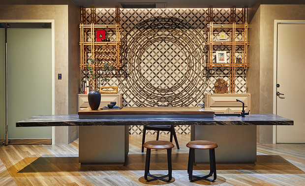 接待沏茶区 Reception and tea making area

彷古面大理石檯，其上为实木桌板製泡茶盘，柜体以氟酸灰镜为主，其独有的雾面色感，以冷调光泽点缀区域；中央背牆面贴金钱砖，蕴藉交流顺利、财源饱满之美意，金属管件烤漆及壁面造型磁砖，藉由花纹及圆之表现，带有诸事圆满含义，简易盆景和大方装饰陈列的泡茶区，怀抱些许禅意，反映业主沉着稳重的处事态度。

The antique surface of the marble table finishes with the gray mirror that via hydrofluoric acid treatment, the unique matte touch of chilly tone beautifies the area. The central back wall is adhered with molding tiles of golden pattern; and assorts with the varnished metallic display shelves to insinuate the perfection of fluent interaction and overflowing wealth through the circular flowery element. The unembellished potted landscape and solid wood tea tray reveals the Zen spirit; while declares the humble and sedate attitude of the proprietor.
