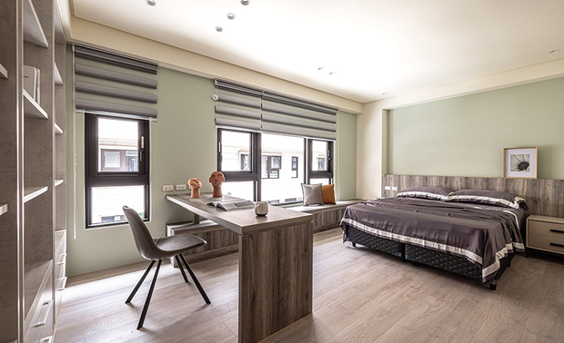 
主卧
Master Bedroom

主卧床头选用质感沉稳的灰色斯曼特漆，镘抹出深浅交织的细緻纹理，并将木皮陈贴于天壁内凹侧、柜面和电视半牆，打造静谧安稳的睡眠场域，比邻更衣间入口装设清玻铁件拉门，不仅放大此处空间感更引入户外阳光，结合柔和的反间接照明，营造丰富的光影层次。

The gray cement paint on the headboard delivers an understated veining shade. Covering the cabinets, the half-wall divider, and around the tray ceiling, the wooden surfaces present a serene sleep zone. Access to the dressing room, the metallic-framed glass sliding door creates an enlarged illusion and invites balmy natural light. The mild reflective lighting design works with natural light to compose multiple layering effects.
