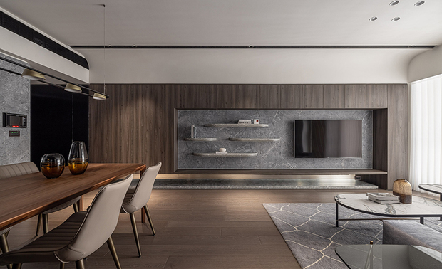 本文由OPEN编辑部撰写

设计概念 Design Concept

内敛低调的色泽荟萃一室沉静，在天光的催化下，衍生出静谧而恆久的生命力，娓娓叙说属于这座宅邸的故事。抛脱现实烦忧的枷锁，让思绪随着石纹随性不羁的纹理自在游走，令肌肤感受木头温暖柔润的质感，在间接柔光的引领下沉淀身心、内观自我，感受与家人、家宅间的温度和气息。

承续屋主对沉静氛围和非凡品味的嚮往，峥嵘设计 廖峥 廖嵘 设计师 运用意象式手法，将抽象的沉稳、宁静之感，透过建材转化为具体的居家环境，进而使人自然地沉浸其中，并以深色调为主轴，于全室採用触感细腻的手刮木地板与肌理精緻的石纹、木质，奠定富有深度的轻奢基调，搭配镜面、铁件赋予俐落线条和多层次光泽，而散佈各处的间接照明，则为空间挹注现代时尚风范；另思及业主对家人的重视，我们将厨房隔牆打通改为通透的玻璃拉门，除了改善此处採光和通风，更以流畅的动线拉近居者距离，让餐厨区成为家宅核心，众人于此共度平实而珍贵的天伦时光。

The interior exudes an understated and subdued color palette, creating an atmosphere of tranquility that seems to resonate with the eternal essence of life under the catalytic effect of natural light. It weaves a captivating tale unique to this abode, liberating one from the shackles of everyday worries. The stone patterns, with their carefree and untamed textures, invite the mind to wander freely, while the touch of wood imparts a warm and gentle sensation. Guided by soft, indirect lighting, one can immerse in self-reflection, savoring the moments spent with family and the heartwarming ambiance of the home.

Drawing inspiration from the homeowner's desire for a serene ambiance and exceptional taste, C.J.HOUSE DESIGN designers Cheng Liao and Jung Liao employ an imagery-based approach to translate abstract feelings of tranquility and calmness into tangible living spaces via carefully chosen materials, seamlessly immersing individuals within. Embracing a deep color scheme as the focal point, we adorn the entire room with delicately textured hand-scraped wood flooring, intricate stone patterns, and elegant wood elements, resulting in a profound and luxurious atmosphere with subtle refinement. Complementing the design, mirrors and metallic works are strategically integrated to accentuate the clean linear feature and a sense of depth and dimension, infusing the space in a modern fashion through indirect lighting. Thoughtfully considering the importance the homeowner places on the family, we replace the kitchen's partition wall with a clear glass sliding door, not only optimizing natural light and airflow but also promoting a smooth flow that brings family members closer together. Transforming the kitchen and dining area into the heart of the home, it becomes a lovely space where the family shares their precious and quality bonding moments.

设计手法 Design Techniques

绵延重浪 激盪天花
Flowing Waves, A Dynamic Ceiling Masterpiece

我们採用圆弧设计过渡餐厨区上方的两支大梁，创造客厅、餐厅和厨房三层渐次排开的天花板造型，形塑如重浪叠叙的流动与层次感，圆润线条柔化空间且具趣味性，成为一道与众不同的别緻天景；在满足美感与艺术性之馀，也将全热交换器、除湿机及吊隐式空调纳入其中，并让灯具结合出风口，使整体呈现乾淨俐落的画面，同时考量室内与户外自然光的互动性，除了中段天壁藉木皮修饰，其馀皆以留白导引天光入室，令整座宅邸更加明亮生气。

We artfully utilize graceful arcs to connect and transition the two large beams above the dining and kitchen area, crafting a three-tiered ceiling design that smoothly unfolds across the living room, dining area, and kitchen. This concept mimics the majestic waves and presents a layering composition of fluidity. And the rounded lines not only soften the ambiance but also add a touch of playfulness, creating a distinctive and charming overhead view. While fulfilling aesthetics and artistic appeal, the ceiling design cleverly incorporates energy recovery ventilation, a dehumidifier, and concealed air-conditioning vents. The integration of lighting fixtures with air outlets creates a clean and cleared-off ambiance. Moreover, we carefully invite the play of light from ambient indoor light and natural outdoor light. While adorning the middle section of the ceiling with wooden veneer accents, the rest is left open to welcome natural light, brilliantly adding a dash of color and vitality to the abode.

巧划空间 俐落收束
Clever Space Design and Neat Organization

此案屏除厨房隔牆，打造宽敞无碍的开放式公领域，并配合T字型动线串连各场域，让居者自在地穿梭其中，彼此照应、相互交流，同时考量居家收纳的必要性，各区皆规划嵌入式橱柜、抽屉、层架等储物空间，保持整洁有序的乾淨景緻，令家宅历久弥新。

In this project, we remove the partition wall in the kitchen to create a spacious and unobstructed open-plan communal space. The layout is intelligently designed with a T-shaped circulation flow, seamlessly connecting different areas, allowing residents to move freely and share precious moments of togetherness. Additionally, prioritizing the importance of home storage, we meticulously set up built-in cabinets, drawers, shelves, and other storage spaces in every room to ensure a tidy and orderly circumstance, presenting a clean and fresh ambiance that withstands the test of time.

友善环境 心安家居
Eco-Friendly Environment, Serene Home Living

除了质感美学和生活机能，我们也致力维护居者的居住健康，採用具环保标章之绿建材，附带全屋除甲醛的服务，再选配隔热效果显着的双层帘，打造自然无毒、冬暖夏凉的优质住宅，软装则以曲弧外型为主，相偕圆弧木作、壁布材质包覆牆角，辅以防滑、天然的手刮木地板，赋予业主一家活动自如、安心无忧的居家环境。

Beyond elevating the aesthetics and functionality of living spaces, we prioritize the well-being of residents by focusing on their living health. We choose eco-friendly building materials with green marks and provide an entire-room formaldehyde removal service, ensuring a residence that promotes a healthy living environment. To enhance comfort and energy efficiency, we deliberately incorporate double-layer curtains with outstanding thermal insulation capabilities, creating an excellent dwelling that is toxin-free, warm in winter, and cool in summer. The soft furnishings feature a curved design, complemented by rounded wooden elements and textured wall coverings. And the use of slip-resistant and natural hand-scraped wood flooring enhances safety and adds a touch of natural warmth to the interior. With these considerations, we meticulously craft a living environment where the family can move freely, feeling at ease and worry-free in their abode.
