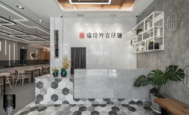 ▲接待区铺陈復古的六角砖并向上延伸至柜檯，另叠加纹路细緻的大理石材，搭配一旁俐落的铁件层架与别具一格的造型logo牆，为延续二十多年的传统美味添入新气象。
